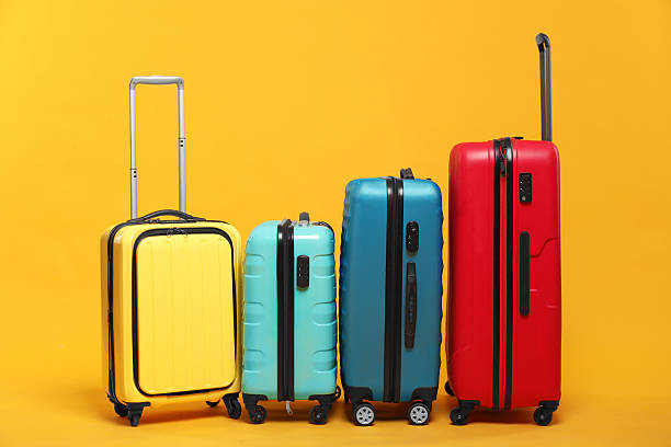 istock Many closed colorful suitcases on orange background 2213223310