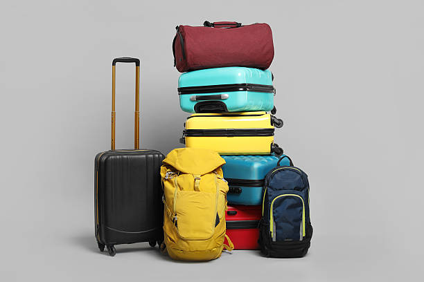 istock Stack of colorful suitcases, backpacks and bag on grey background 2213223343