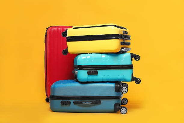 istock Many closed colorful suitcases on orange background 2213223405