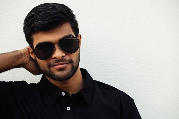 istock Stylish man in sunglasses posing against a textured white background 2213223554