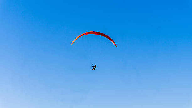istock Solo Paraglider Flying Under Clear Blue Sky 2213225275