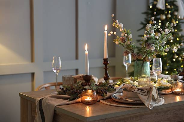 istock Christmas table setting with stylish dishware, glasses and burning candles in festive decorated room 2213231977