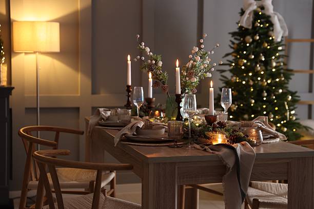 istock Christmas table setting with stylish dishware, glasses and burning candles in festive decorated room 2213232028