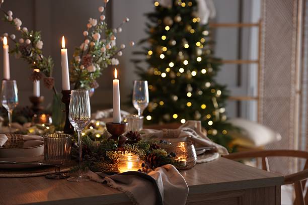 istock Christmas table setting with stylish dishware, glasses and burning candles in festive decorated room 2213232037