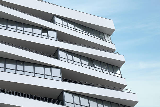 istock Modern building with many windows against blue sky, low angle view 2213232204