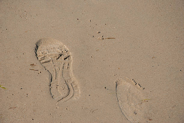 Footprints on sandy beach capturing tranquil summer vibes and seashore adventure, perfect for coastal escapes and nature retreats. Digital nomad lifestyle. Remote work.