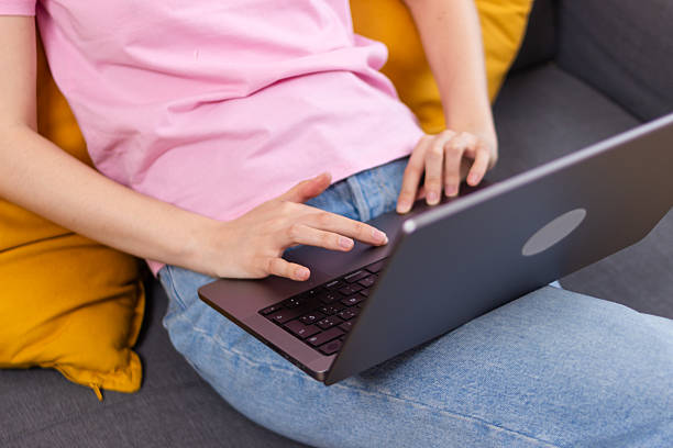 istock Young woman working from home using laptop on sofa 2213233755