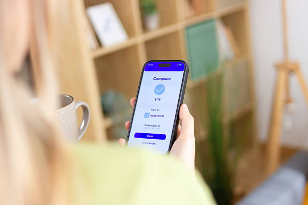 istock Woman making online payment using mobile phone app at home 2213234650