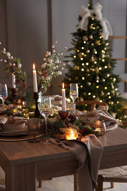 istock Christmas table setting with stylish dishware, glasses and burning candles in festive decorated room 2213234651