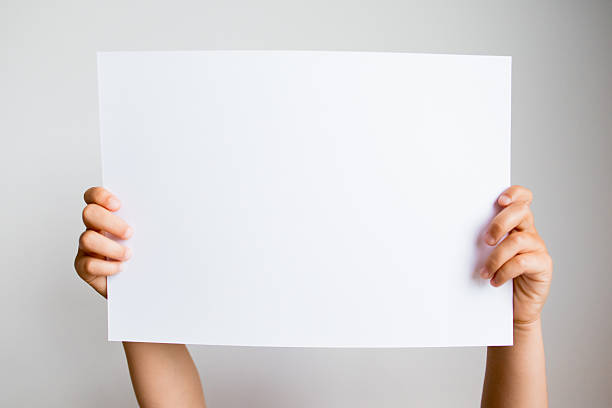istock Hands holding blank white paper sheet against neutral background 2213235010