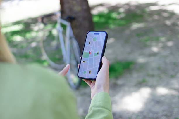 istock Woman using navigation app on smartphone while cycling in park 2213235146