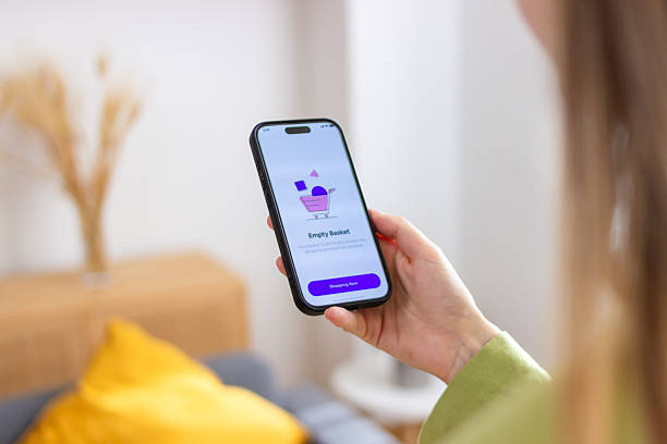 istock Woman holding smartphone with empty shopping basket on screen 2213235660