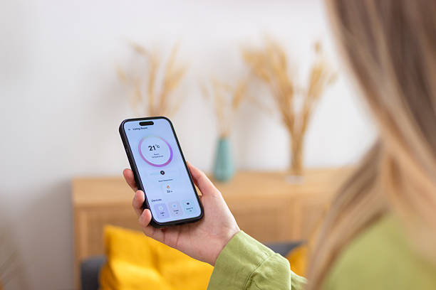 istock Woman using smart home application on mobile phone for temperature control 2213235905