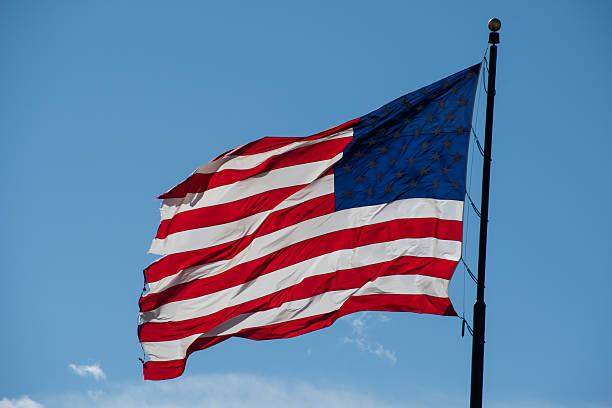 istock American flag waving full against blue sky 2213237300