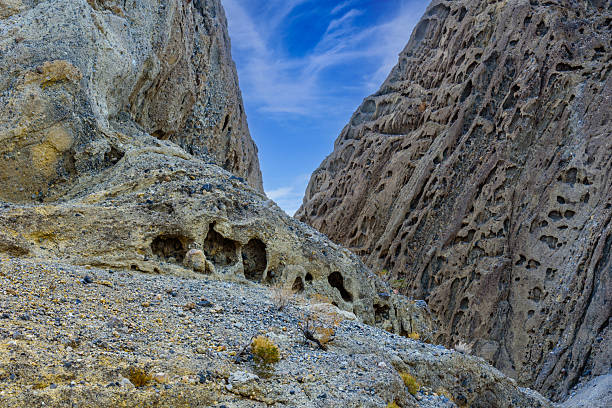 Hole in the Wall Canyon takes its name from a natural opening eroded into the rock, a testament to the relentless power of flash floods and ancient weathering. Over countless centuries, water carved through these layered cliffs, leaving behind the striking holes that marks the heart of the canyon.  Hole in the Wall Canyon is in Death Valley National Park near Furnace Creek, California, USA.
