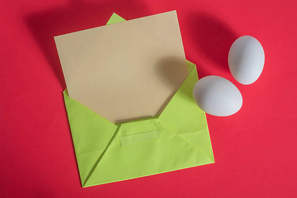 istock Colorful envelopes and eggs on a vibrant red background for an Easter concept. 2213240704