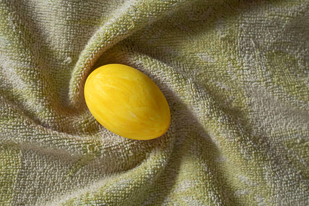 Top view of a yellow egg on a green cloth with natural light,