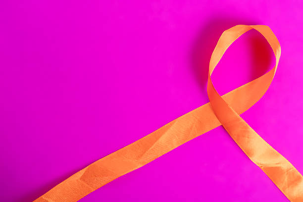 istock Orange ribbon on a vibrant pink background symbolizing awareness and creativity. 2213246680