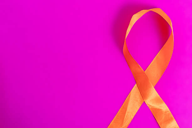 istock Orange awareness ribbon on a vibrant pink background for campaign support. 2213246696