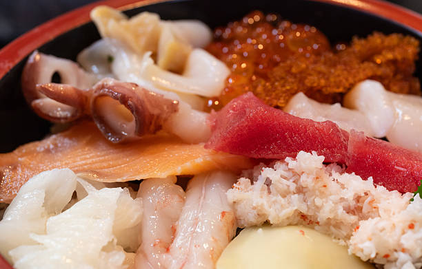 A close up of a bowl of kaisendon, various kinds of sashimi with rice below.