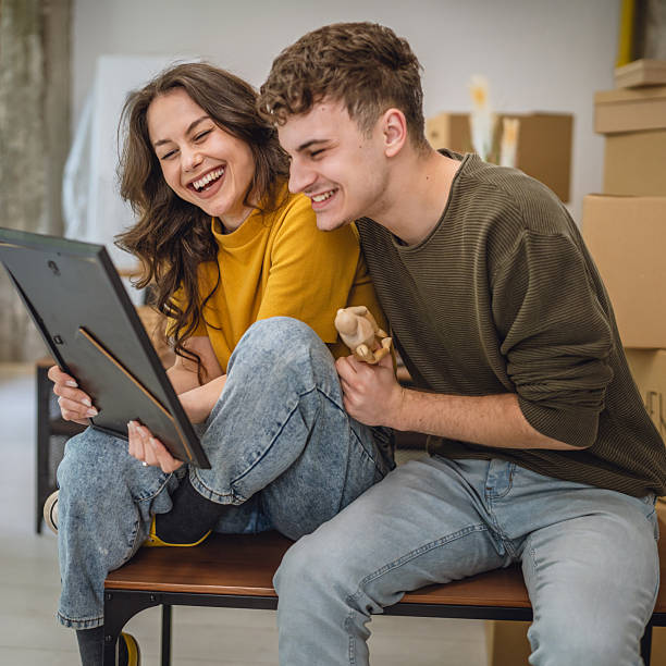 istock Happy adult couple having fun while unpacking boxes together 2213251243