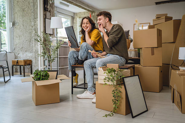 istock Happy adult couple having fun while unpacking boxes together 2213251267