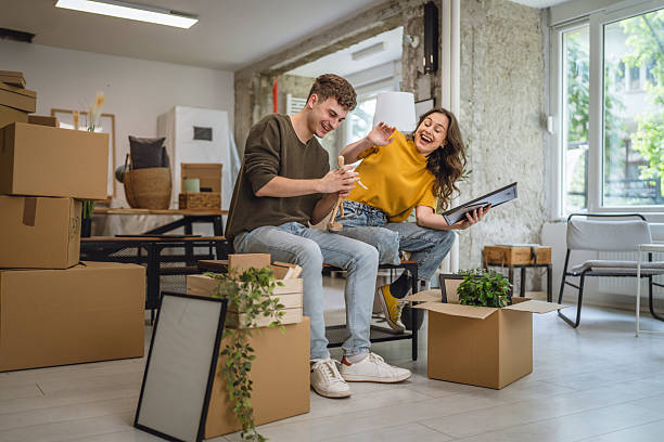 istock Happy adult couple having fun while unpacking boxes together 2213251268