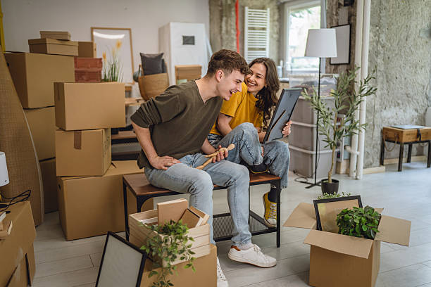 istock Happy adult couple having fun while unpacking boxes together 2213251269
