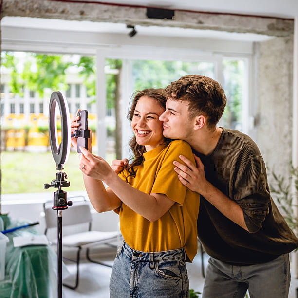 istock couple v-loggers use mobile phone and ring light for record video 2213251344