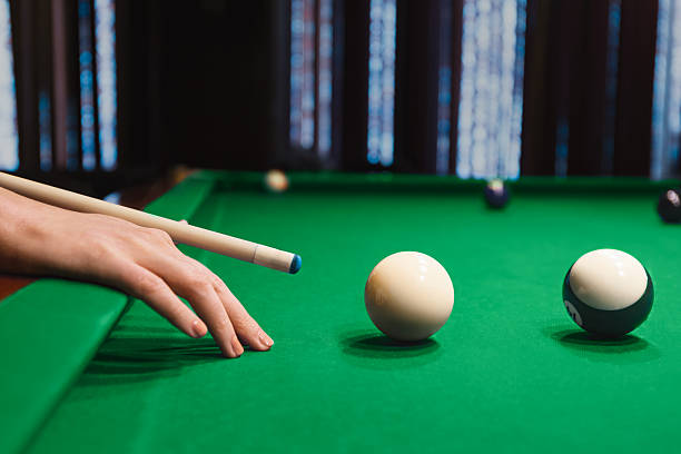 istock Female Player Aims Cue Toward Billiard Balls 2213251724