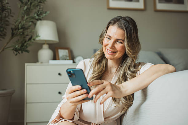 istock Mature woman using smartphone during morning in bedroom 2213251871