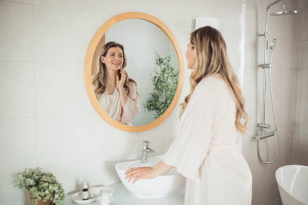 istock Mature woman applying moisturizer on face 2213251911