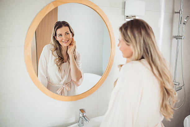 istock Mature woman applying moisturizer on face 2213251916