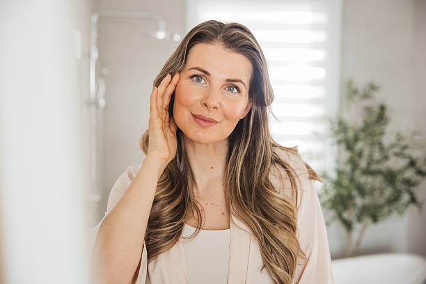istock Mature woman applying moisturizer on face 2213251924