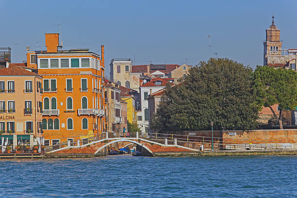 Venice, Italy - December 19, 2012: Arch Bridge for Pedestrians Hotels and Houses at Giudecca Canal Sunny Winter Day in Old Town.