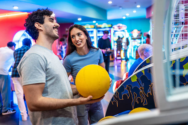 istock Young couple playing arcade basketball game on a date 2213256199