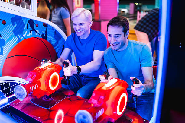 istock Two friends having fun playing arcade games together at amusement park 2213256225