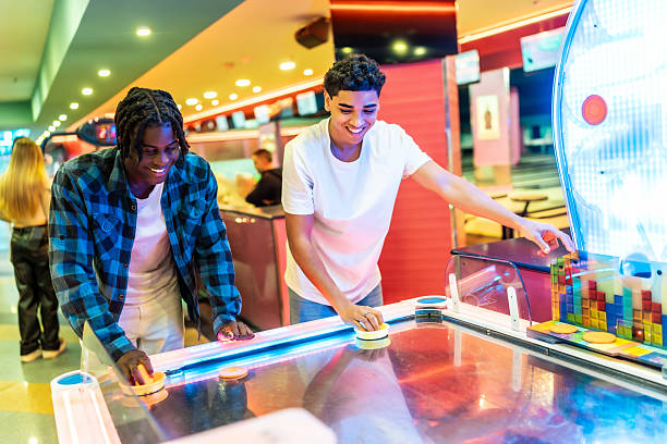 istock Two young men playing air hockey in an amusement arcade 2213256227