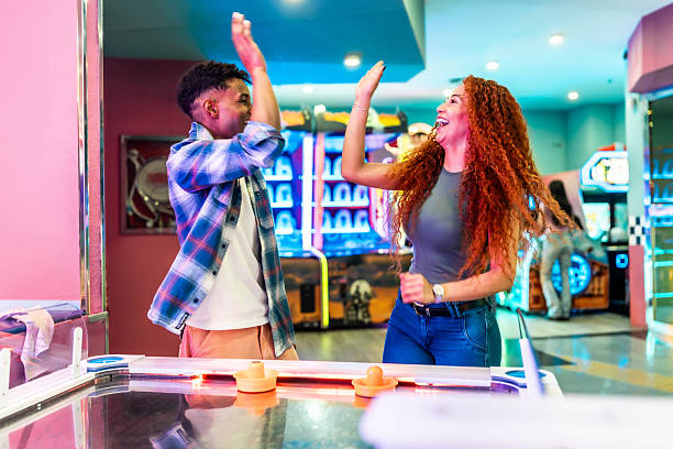 istock Young couple giving high five while playing air hockey in an arcade 2213256238