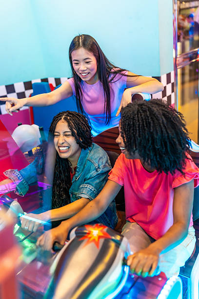 istock Young women playing arcade game together in amusement park 2213256244