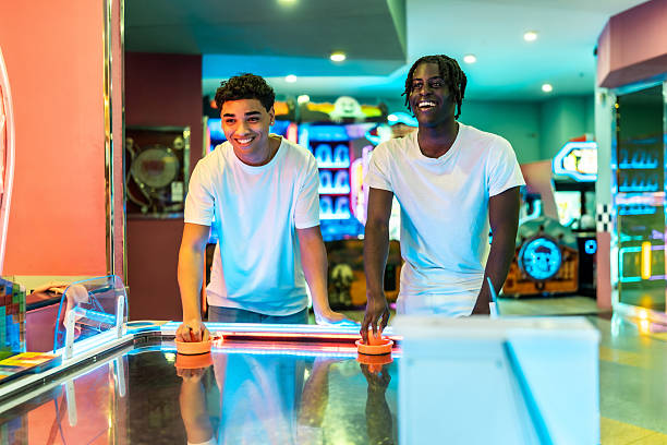 istock Two young men playing air hockey in an amusement arcade 2213256305
