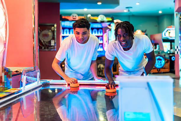 istock Two young men playing air hockey in amusement arcade 2213256329