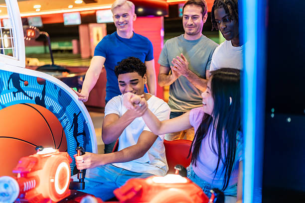 istock Young multiethnic friends having fun playing arcade basketball game 2213256337