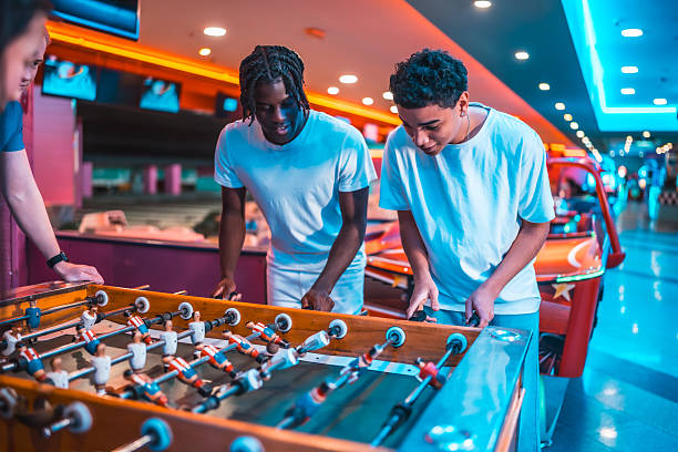 istock Teenagers playing foosball in amusement arcade 2213256358