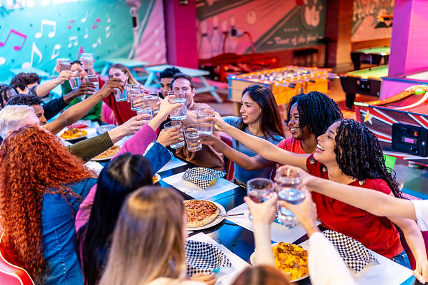 istock Young multiethnic friends toasting drinks at bowling alley restaurant 2213256442