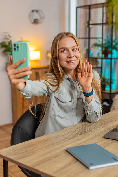 istock Caucasian mature woman freelancer using smartphone having video call smiling while sitting at table 2213261268
