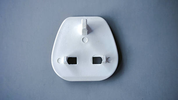 White Electrical Plug Adapter with Three Prongs on a Gray Surface
