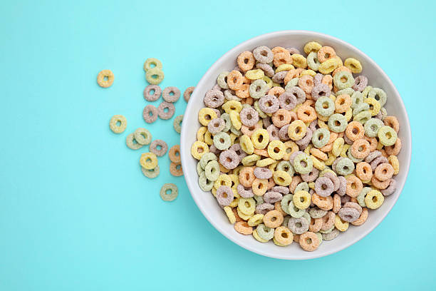 istock Tasty cereal rings in bowl on light blue table, top view. Space for text 2213273109