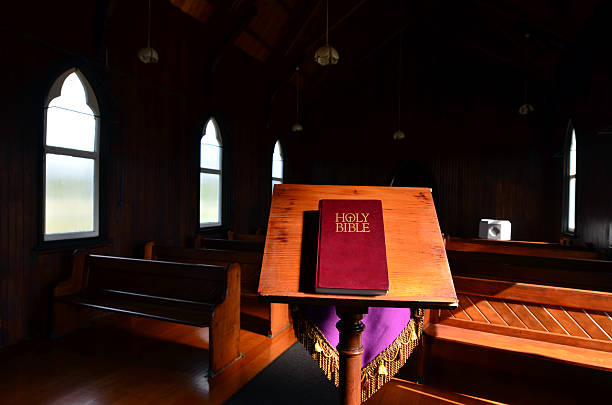 Holy Bible with a pink roses flowers on top, on white background, flat lay. Concept for faith, spirituality, and religion. Bouquet of flowers and Bible. Easter concept.