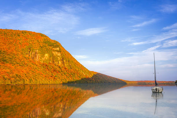 Vermont's tranquil Lake Willoughby on a beautiful autumn morning with a sailboat resting